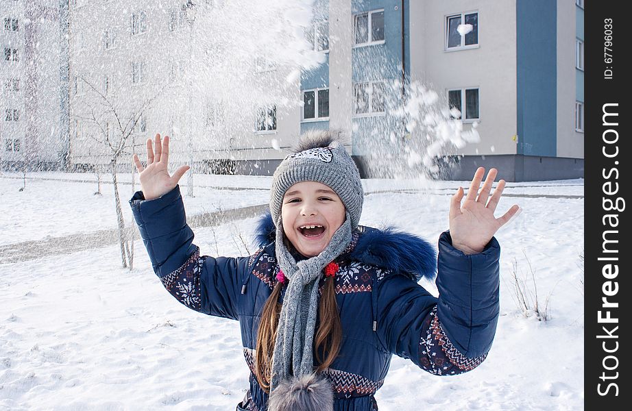 Girl playing in the snow outside closeup