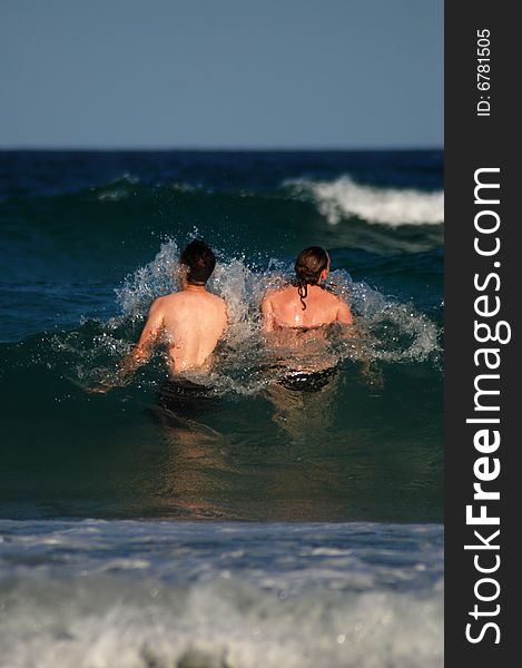 A young couple in the surf with copy space above and below. A young couple in the surf with copy space above and below