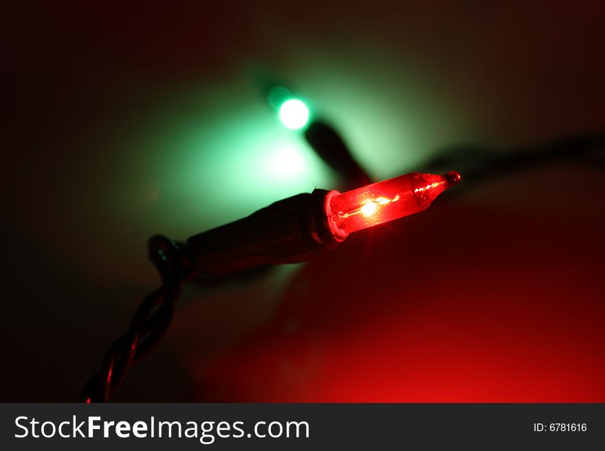 Red and green Christmas lights casting green and red hues on the background