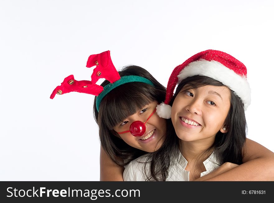 Girls in funny head wear hugging each other at a Christmas party. Girls in funny head wear hugging each other at a Christmas party