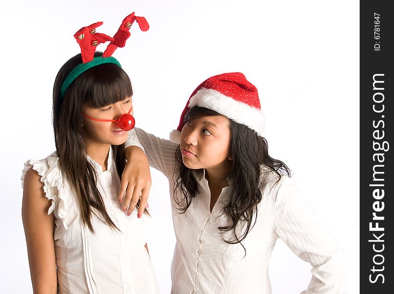 Girl friends in funny head wear gossiping at a Christmas party