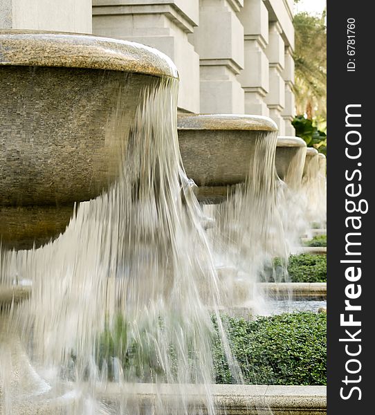 Fountains fashioned after giant goblets lined a columned wall in a Victorian styled grand  building. Fountains fashioned after giant goblets lined a columned wall in a Victorian styled grand  building
