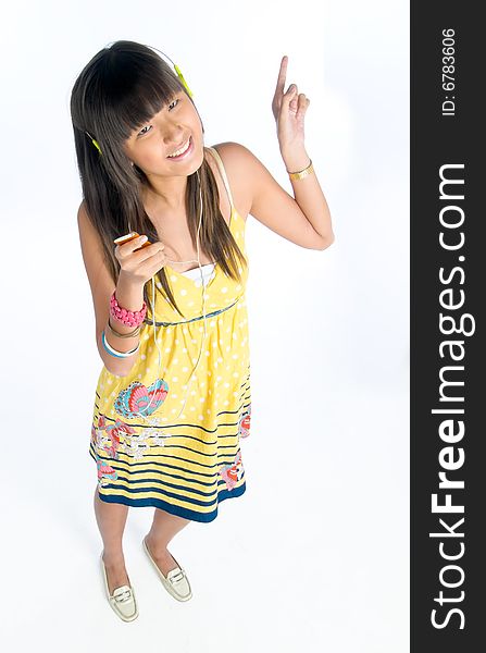 Tall lanky happy smiling Asian girl dancing to music played on her tiny portable music player