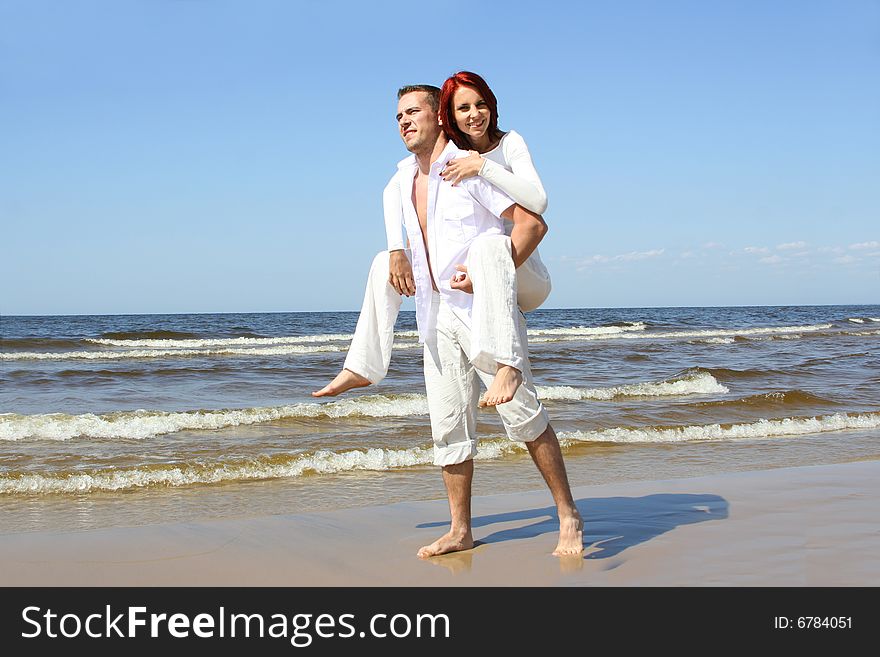 Beautiful yound couple relaxing on the beach. Beautiful yound couple relaxing on the beach