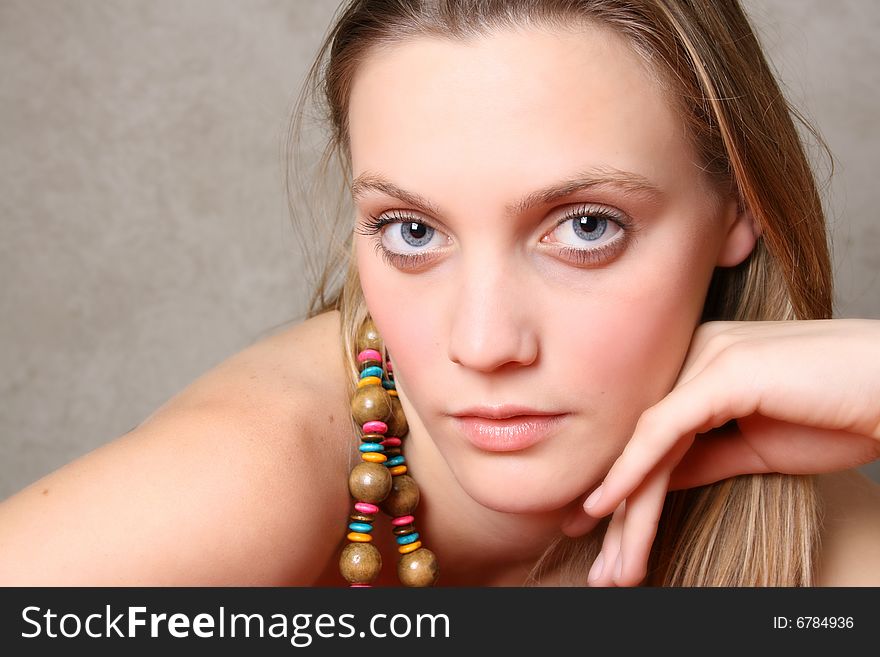 Beautiful female model with blue eyes and a string beads