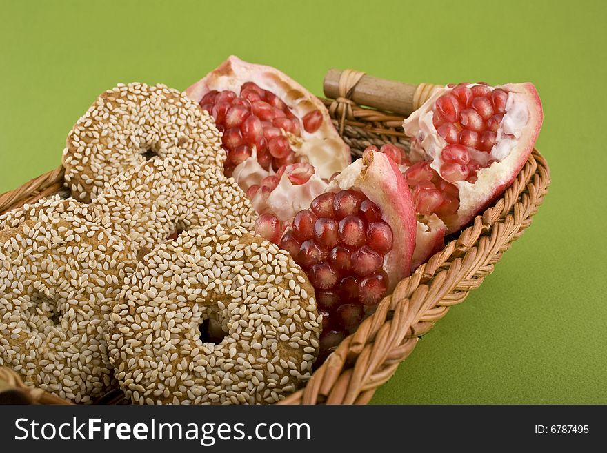 Pomegranate close-up in basket isolated on green background