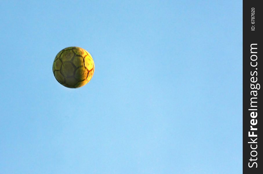 Yellow football on sky background