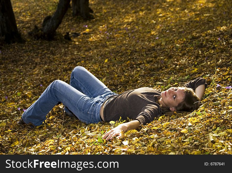Young woman laying in autumn forest. Young woman laying in autumn forest
