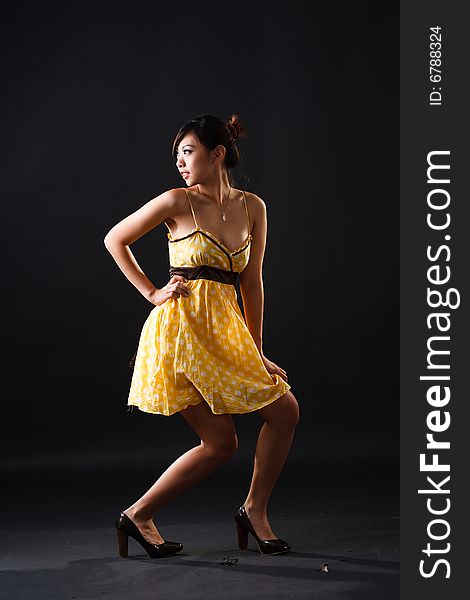 Playful asian girl in yellow polka dot dress. Playful asian girl in yellow polka dot dress