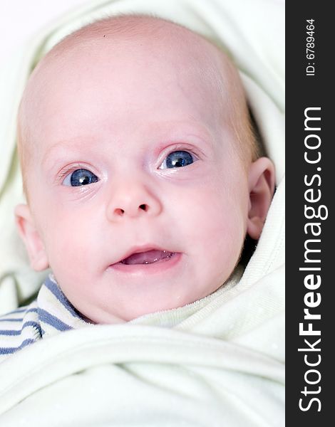 a little cute newborn baby  lying on bed with her eyes open