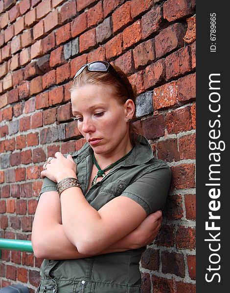 Portrait of unhappy woman near the brick wall. Portrait of unhappy woman near the brick wall