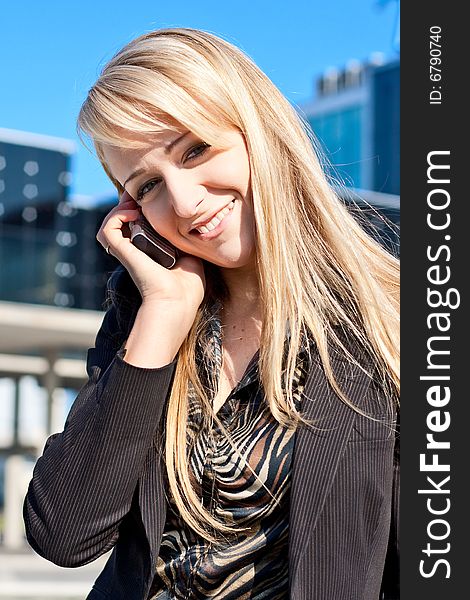 Portrait of a young smiling business lady talking on a phone. Portrait of a young smiling business lady talking on a phone