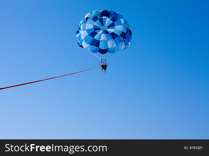Two people parasailing over the ocean. Two people parasailing over the ocean