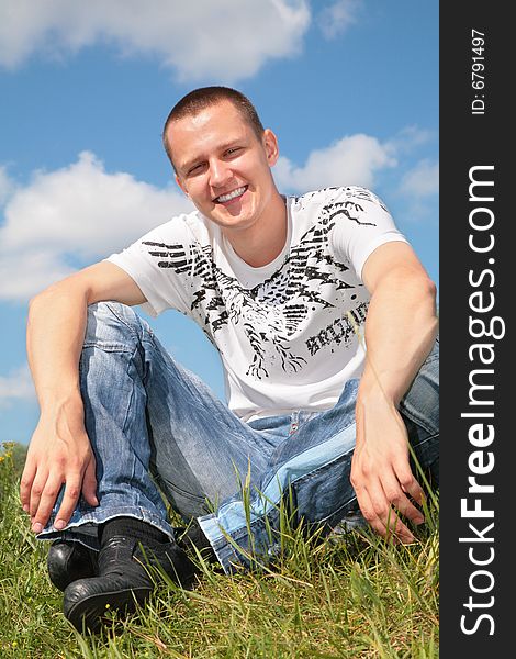 Young Man Sits On Grass