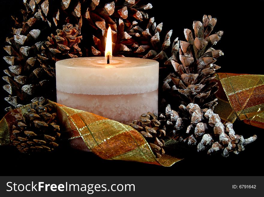 Flickering candle in pine cones and ribbon. Flickering candle in pine cones and ribbon.