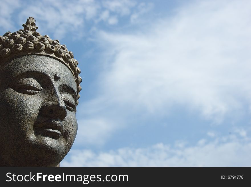 Buddha's face against a blue sky. Buddha's face against a blue sky.