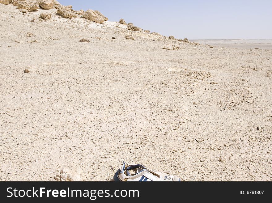 Remote and rocky desert landscape formed millions of years ago. An old abandoned shoe is visible in the foreground. Remote and rocky desert landscape formed millions of years ago. An old abandoned shoe is visible in the foreground.
