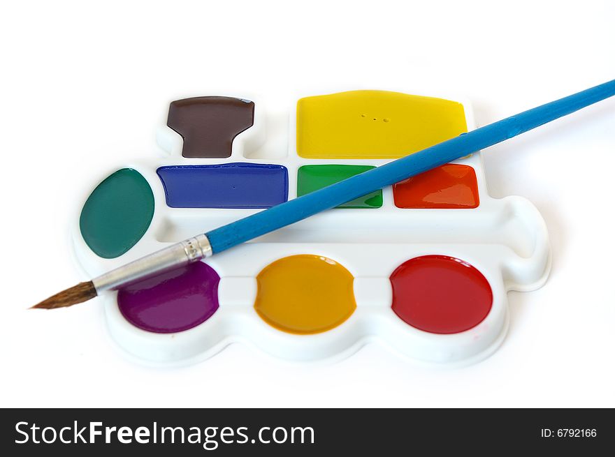 Box of watercolors and a brush isolated on a white background. Box of watercolors and a brush isolated on a white background.