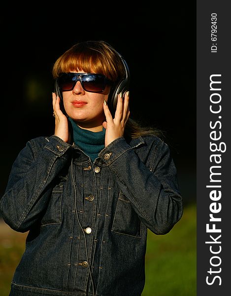 Pretty girl with headphones looking through the glasses. Pretty girl with headphones looking through the glasses