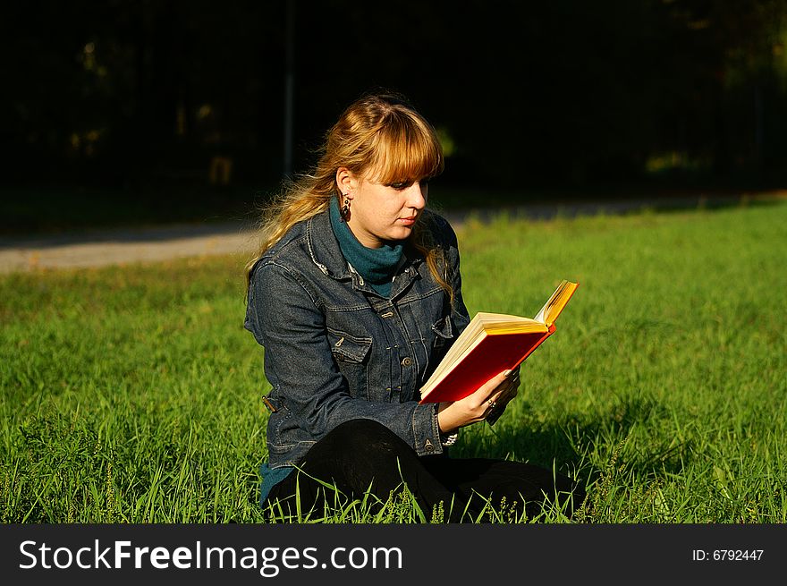 Girl reading the book sitting on the grass