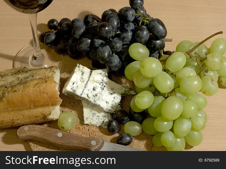 Bread, cheese and grapes with a glass of red wine. Bread, cheese and grapes with a glass of red wine