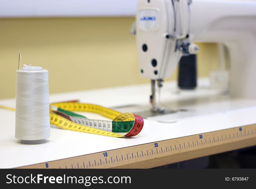 A sewing machine and thread spool on a table