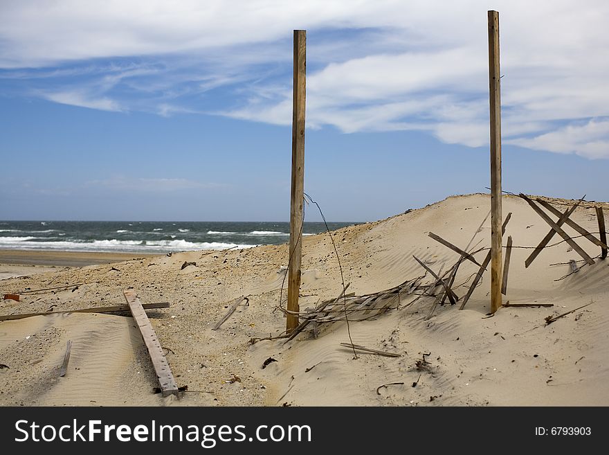 A windy beach with a fence that is in place to keep the sand in place. The picture is taken at the Outer Banks, NC, USA