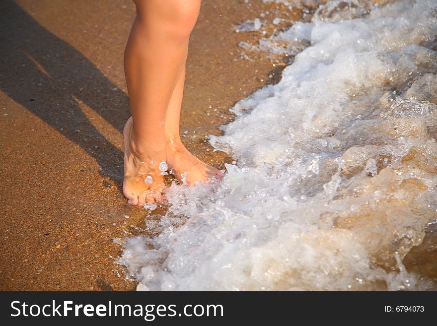 Legs on wave on sand