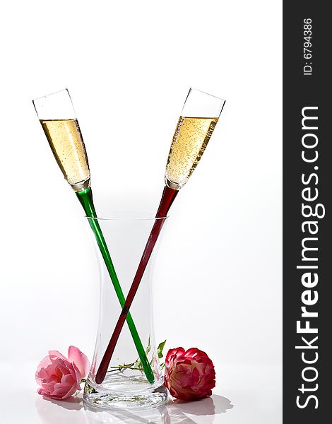 Two flutes of champagne and rose on white background