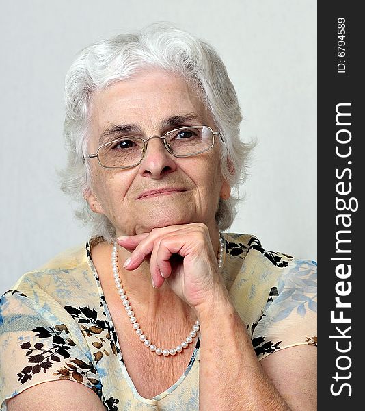 Portrait of senior lady over a gray background