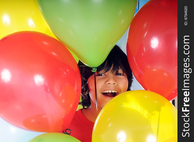 A happy Asian-Indian boy surrounded by colorful balloons. A happy Asian-Indian boy surrounded by colorful balloons.