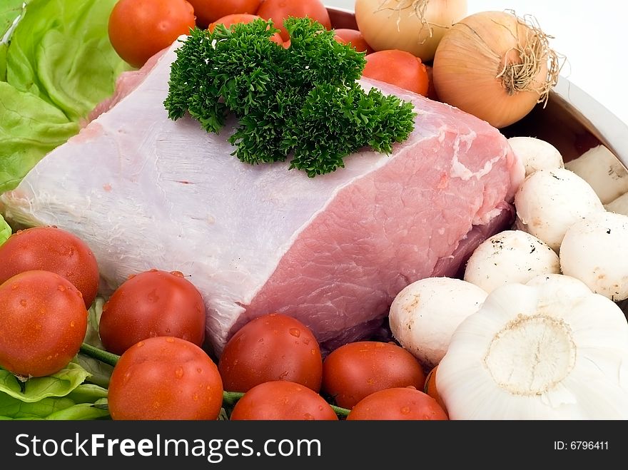 Raw pork on the plate with tomatoes,garlic and mushrooms