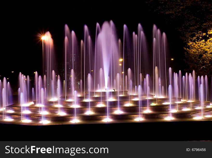 Illuminated fountain at dark night