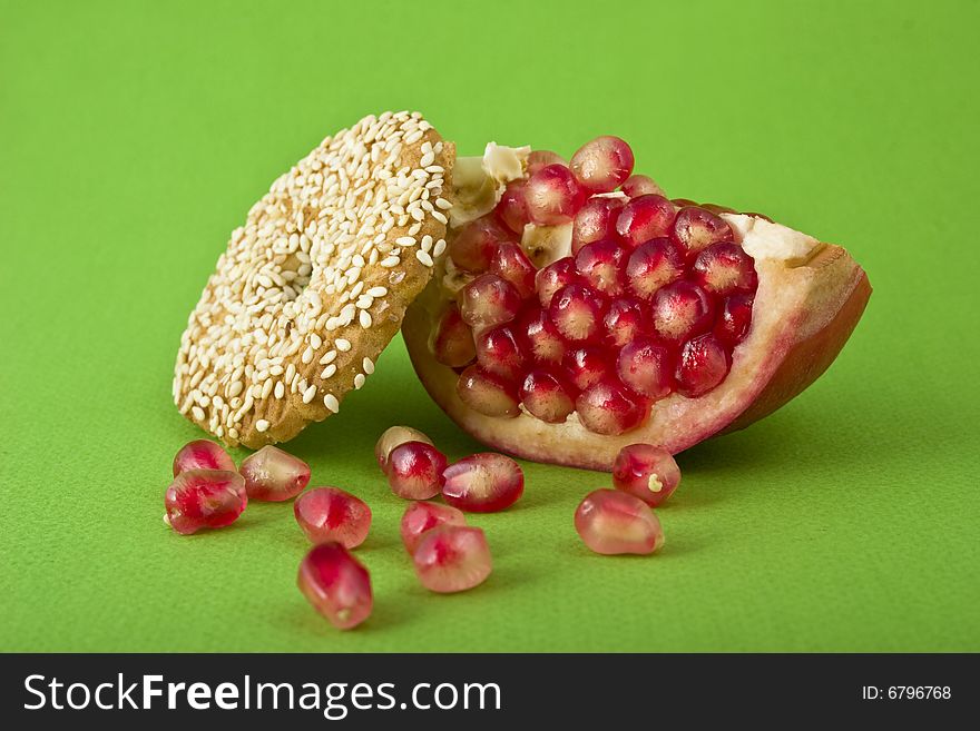 Pomegranate and cookies close-up isolated on green background. Pomegranate and cookies close-up isolated on green background