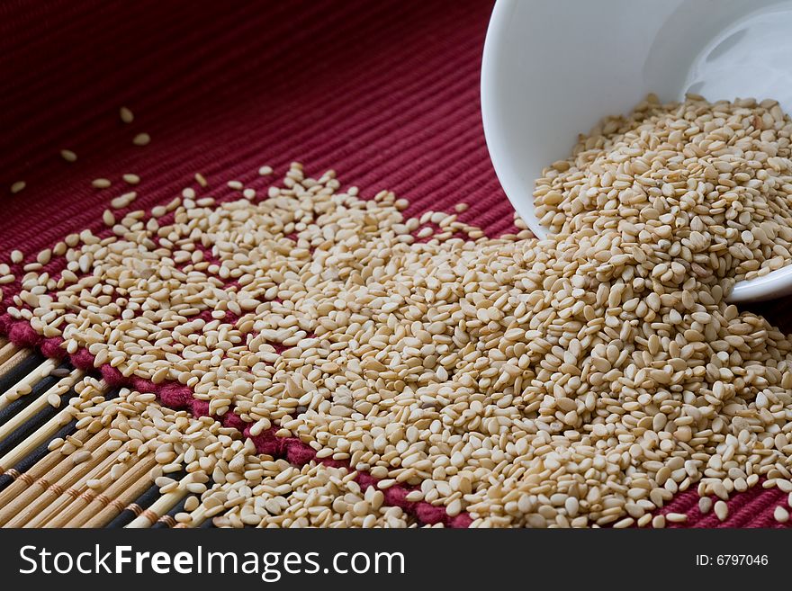 Sesame seed on white bowl over red background