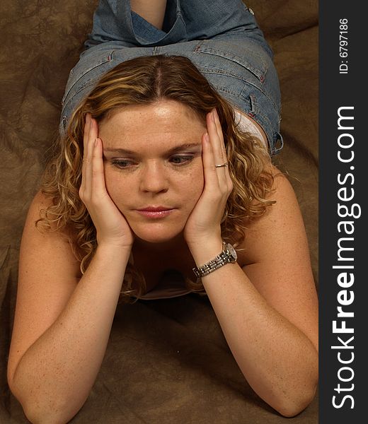 Portrait of a brown haired model in a relaxed pose lying down. Portrait of a brown haired model in a relaxed pose lying down