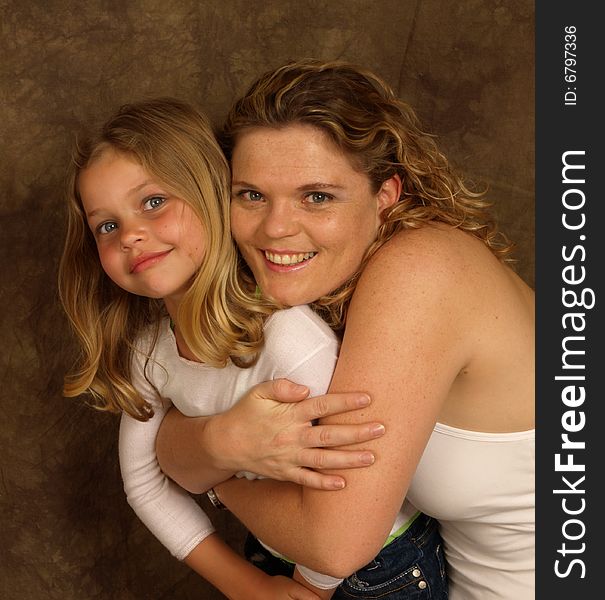 A portrait of a mother and daughter hugging. A portrait of a mother and daughter hugging