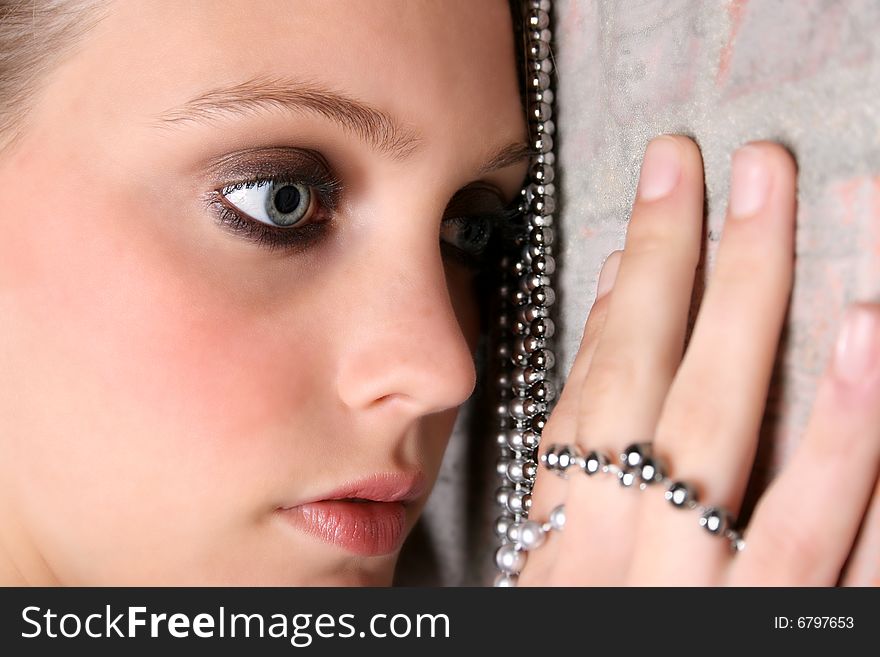 Beautiful model with blue eyes holding strings of beads. Beautiful model with blue eyes holding strings of beads