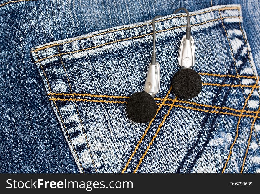 Blue denim jeans with headphones in back pocket