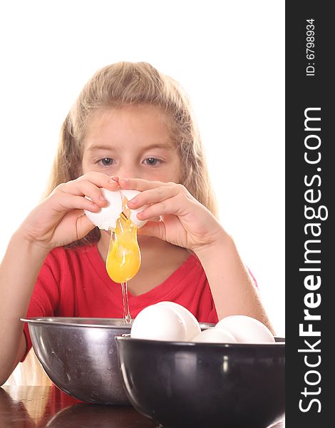 Little girl cracking an egg over bowl isolated on white