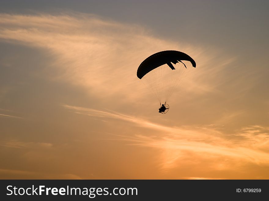 Paramotor glider silhouette over sunset sky. Paramotor glider silhouette over sunset sky