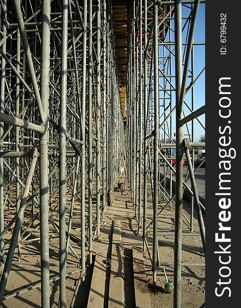 Inside metal scaffold supporting road building. Inside metal scaffold supporting road building