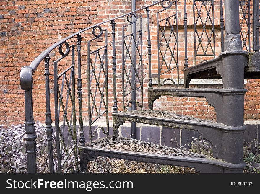 Black metal spirel staircase near a brick wall. Black metal spirel staircase near a brick wall.