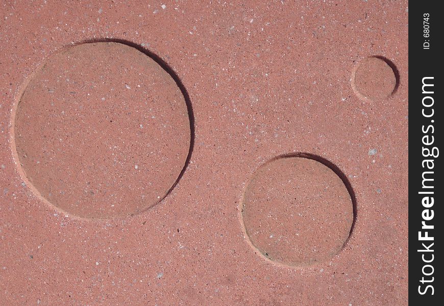 Circles set into red granite. Circles set into red granite