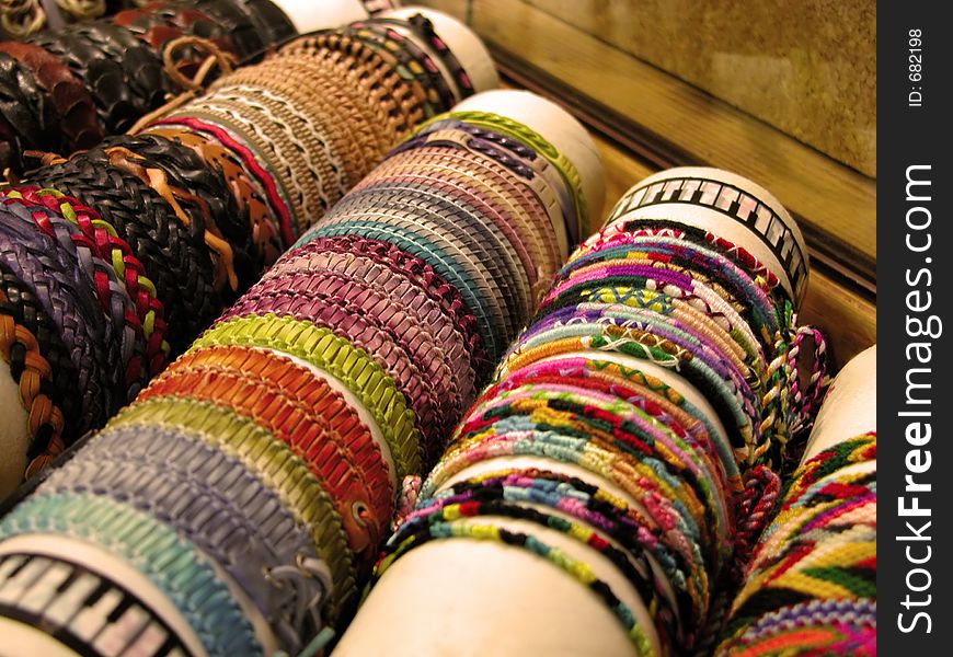 Textile and leather bracelets,flower power style on a market stall.Selective focus. Textile and leather bracelets,flower power style on a market stall.Selective focus.
