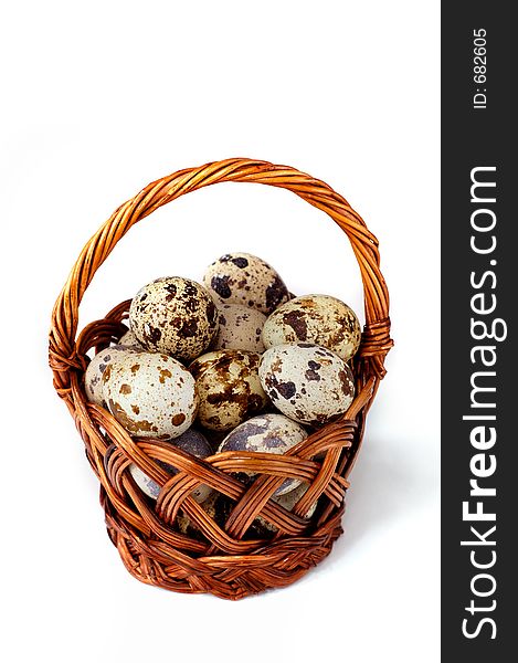 Easter quail eggs in a basket isolated on white background. Easter quail eggs in a basket isolated on white background