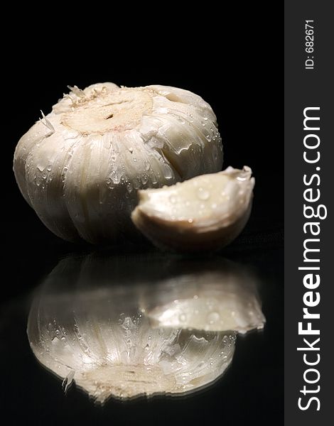 Still life of garlic with reflex on black background