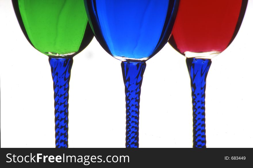 Three wine glasses filled with green, blue, and red colored liquid. Three wine glasses filled with green, blue, and red colored liquid.