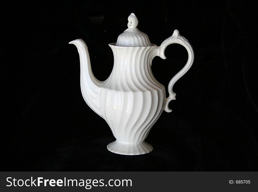 White fancy teapot on a black background. White fancy teapot on a black background