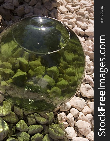 A green glass ball on some gravel. A green glass ball on some gravel.